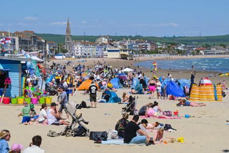 Busy beach with sunbathers in Weymouth, Dorset.