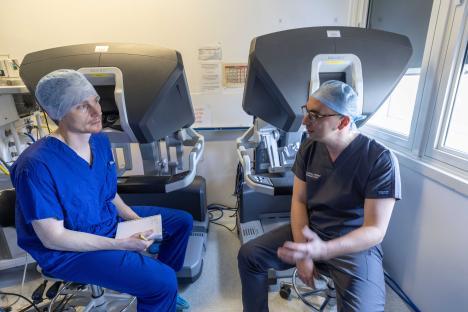 A journalist interviews a surgeon using robotic keyhole surgery.