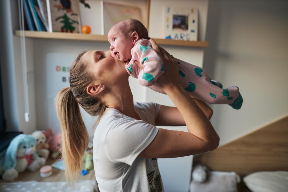 A single mother kisses her newborn baby.