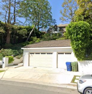 Two-car garage and house on a hill.