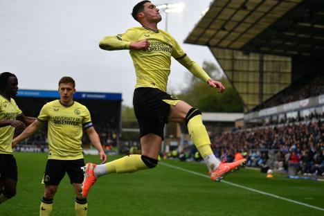 Lloyd Jones celebrates scoring a goal during a soccer match.