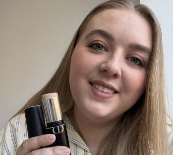 Woman holding Dior foundation stick.