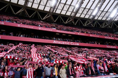 Athletic Club stadium fans with red and white scarves.