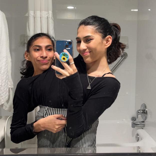 Conjoined twins Carmen and Lupita taking a mirror selfie.