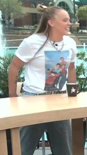 JoJo Siwa on a TV show, wearing a t-shirt with a family photo on it.