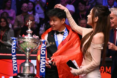 Zhao Xintong, the first Chinese World Snooker Championship winner, with his girlfriend and trophy.