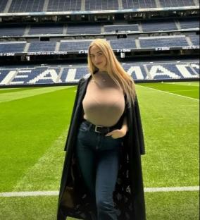Woman standing on a soccer field in a stadium.