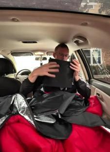 Man in car showing how he lives and works from his vehicle.