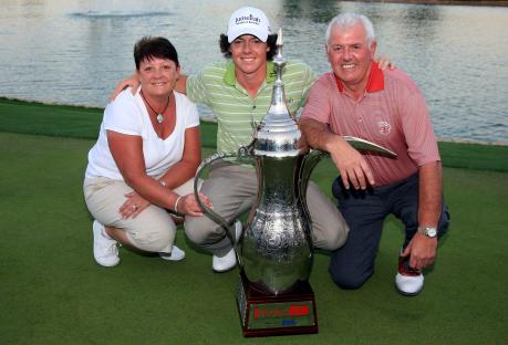 Rory McIlroy with his parents and the Dubai Desert Classic trophy.