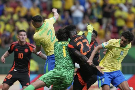 Brazil's goalkeeper Alisson and Colombia's Davinson Sanchez collide while battling for the ball during a FIFA World Cup 2026 qualifying soccer match at Mane Garrincha stadium in Brasilia, Brazil, Thursday, March 20, 2025. (AP Photo/Eraldo Peres)