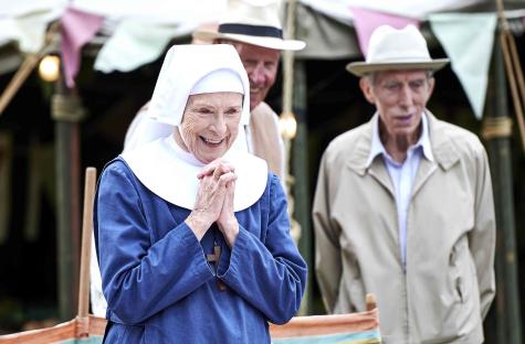 Sister Monica Joan (Judy Parfitt) in a blue habit, hands clasped in prayer.