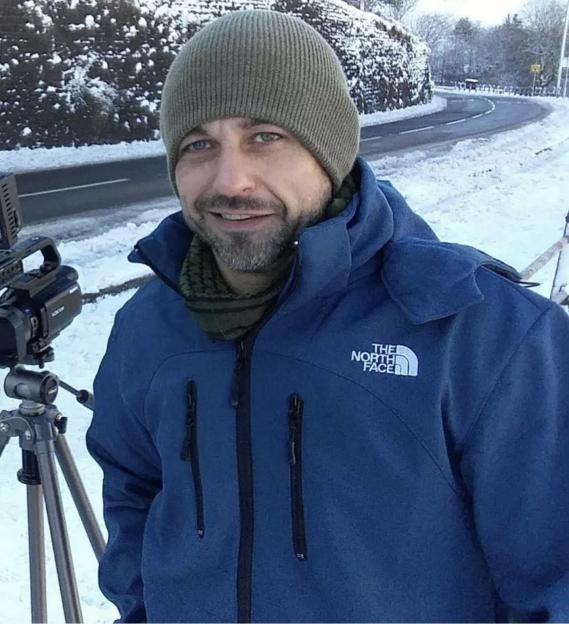 Steven Thomas, a former RAF airman, standing outside in the snow in a blue coat and a knit cap.
