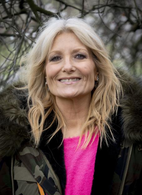 Gaby Roslin smiling and wearing a camouflage jacket and pink top.