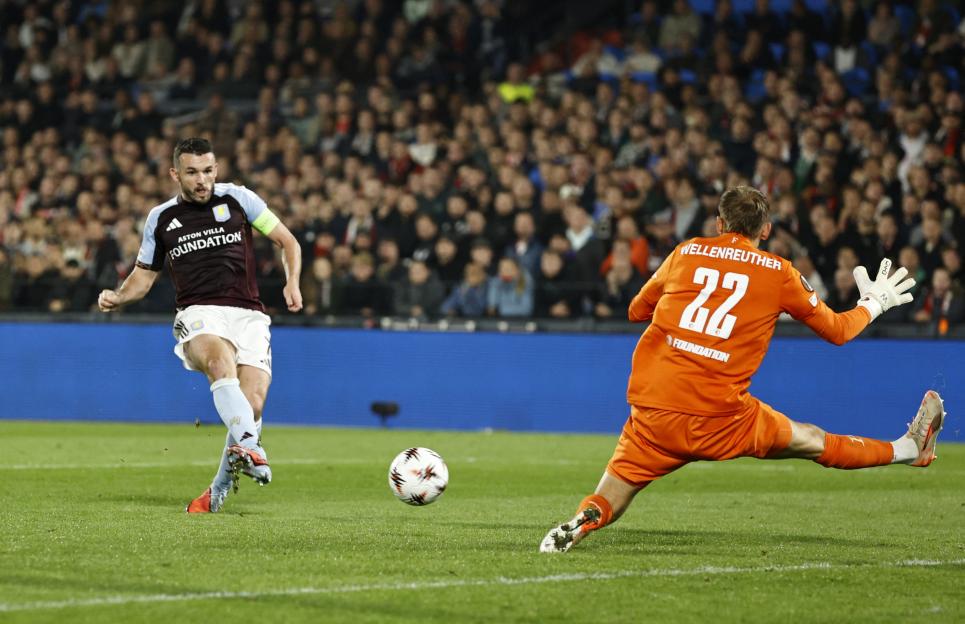 Aston Villa's John McGinn scores against Feyenoord's goalkeeper.