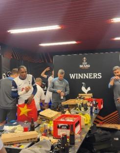 Tottenham Hotspur players celebrating in a messy dressing room after a win.