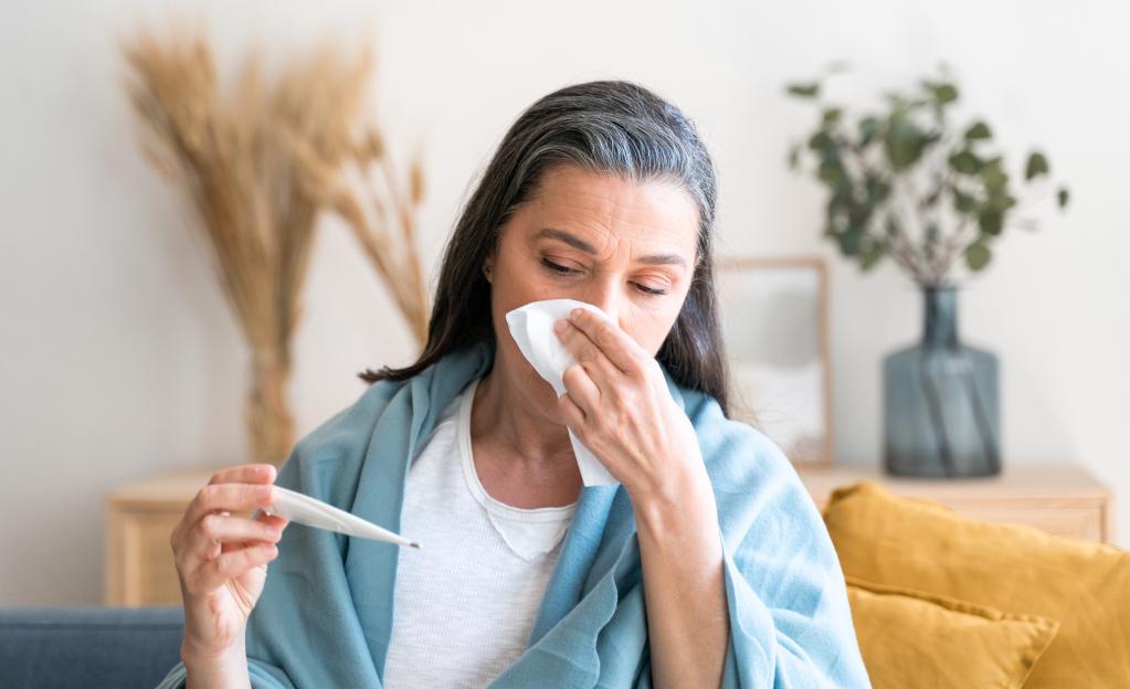 Sick woman checking her temperature.