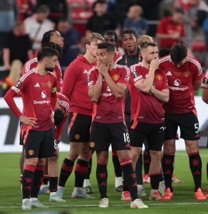Manchester United players looking dejected after a soccer game.