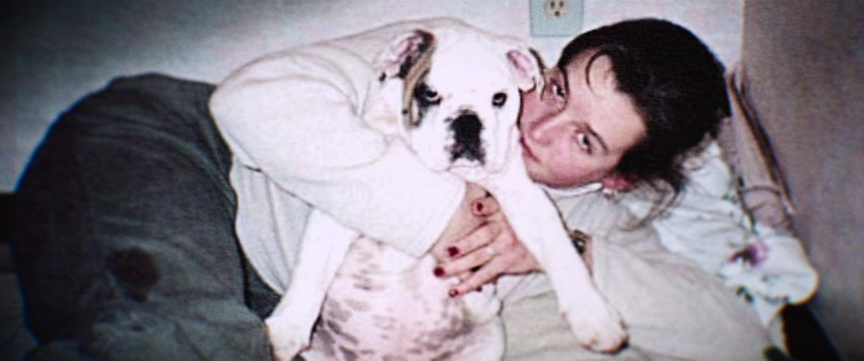 Photo of Amy Bradley hugging a dog.