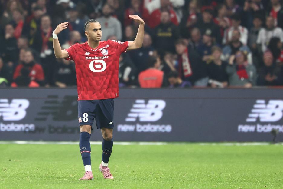 Lille midfielder Ethan Mbappe celebrates scoring a goal, with arms raised.
