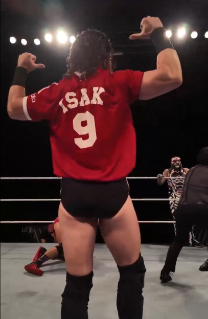 Wrestler Isak 9 in red jersey, viewed from behind, gesturing.