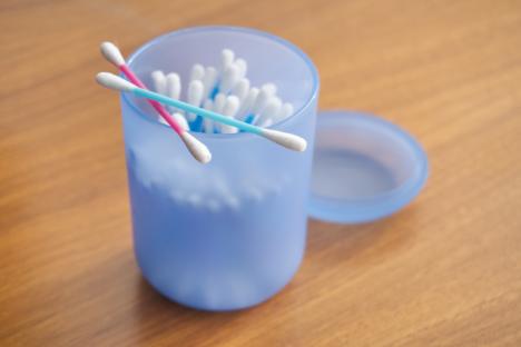 Multicolored cotton swabs in a blue container.
