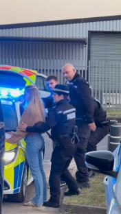 Police officers arresting a woman.