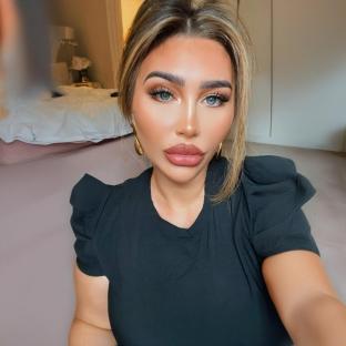 Woman with blonde hair and makeup wearing a black shirt.