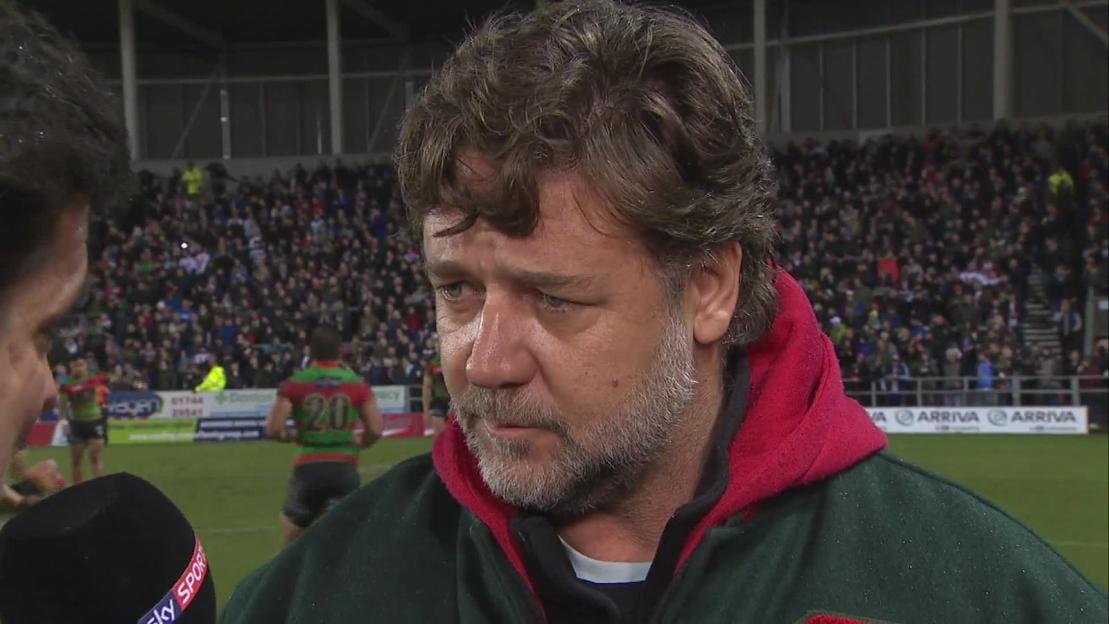 Russell Crowe being interviewed at a sporting event.