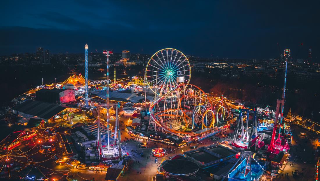 Aerial view of a brightly lit Christmas market and amusement park at night.