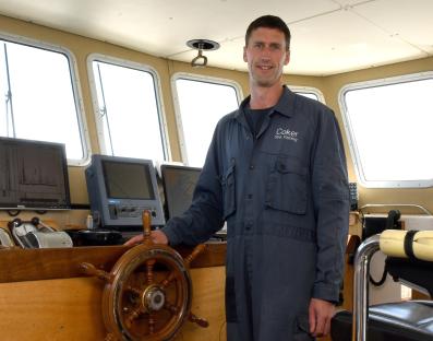 Skipper Matt Coker in the wheelhouse of his boat.