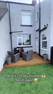 Finished house exterior with new deck and artificial turf.