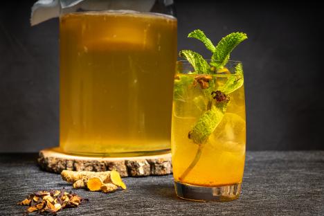 Glass of turmeric kombucha with mint.