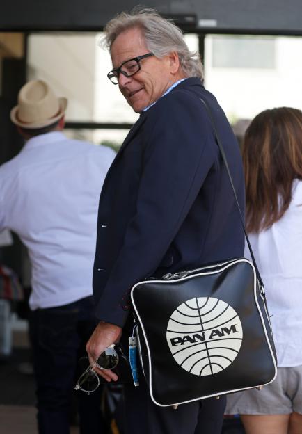 Craig Carter, CEO of PAN AM, heading toward the terminal with a black Pan Am bag.
