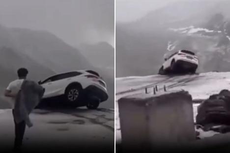 Terrifying moment car dangles precariously over sheer cliff drop sparking frantic mission to save occupants inside