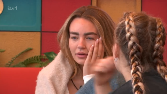 Two women comforting each other.
