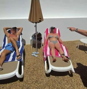 A woman confronts a couple sunbathing by a pool.