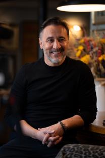 Portrait of a smiling man wearing a black sweater.