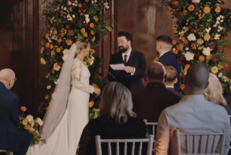 A wedding ceremony with a bride and groom standing before an officiant.