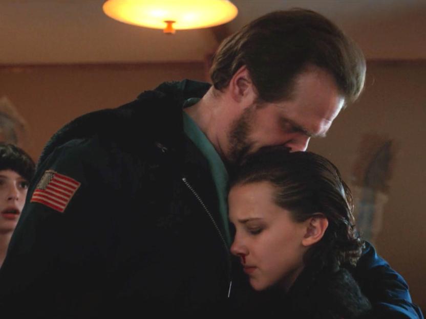 David Harbour as Hopper hugging Millie Bobby Brown as Eleven in Stranger Things.