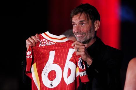 Jurgen Klopp holding a signed Trent Alexander-Arnold Liverpool jersey.