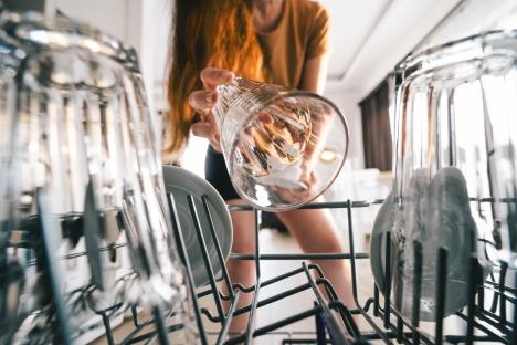 Woman unloading a dishwasher.