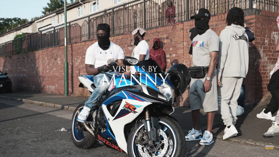 Men standing around a motorcycle.
