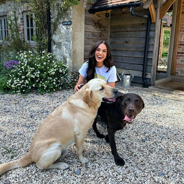 Woman smiling with two Labrador Retrievers.