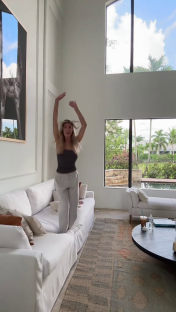 a woman is jumping in the air in a living room