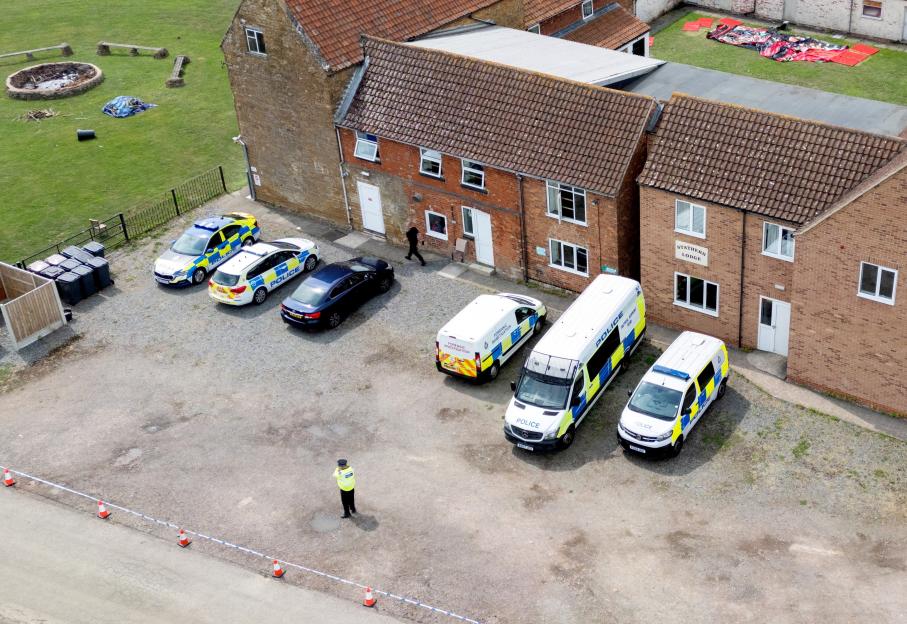 Aerial view of police vehicles and officers outside Stathern Lodge following a poisoning incident.