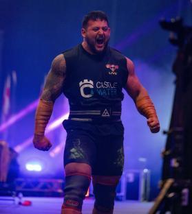Strongman competitor shouting in victory.