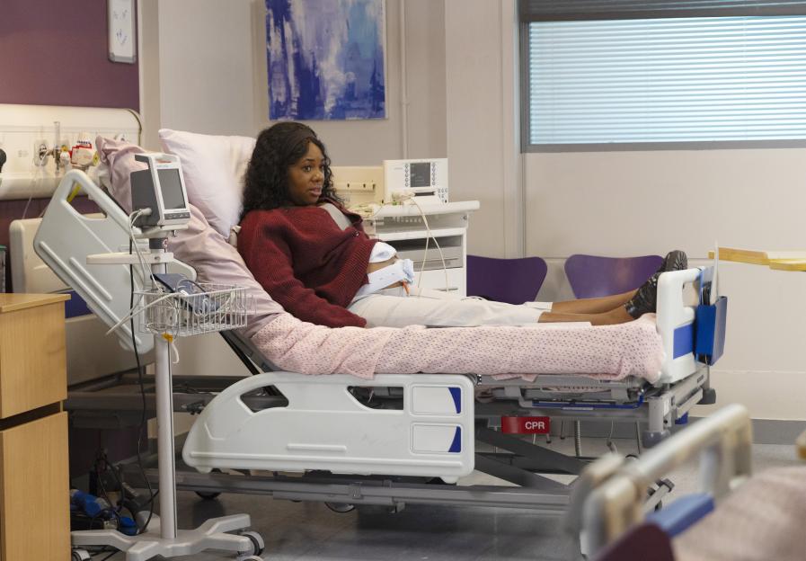 A woman lies in a hospital bed, experiencing false labor.