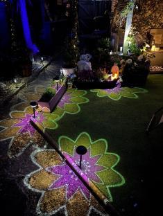 Nighttime garden scene with illuminated flower designs on the ground.