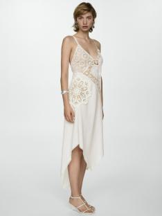 Woman in off-white lace dress and white sandals.
