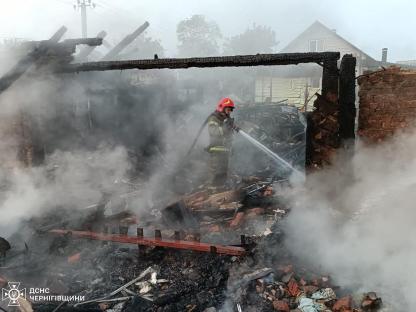 Firefighter extinguishing a fire at a damaged building.